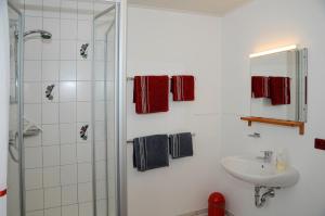 a white bathroom with a sink and a shower at Gabis-ferienwohnung in Schwörsheim