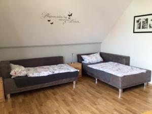 two beds and a couch in a room at Gabis-ferienwohnung in Schwörsheim +1 photo