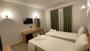 une chambre d'hôtel avec deux lits et une télévision dans l'établissement Perlina Küçükköy, à Ayvalık