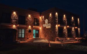 un bâtiment avec un panneau sur le côté la nuit dans l'établissement Perlina Küçükköy, à Ayvalık