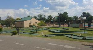 een park met een gebouw en een gebouw met groene daken bij Pendleberry Grove 33 in Bela-Bela