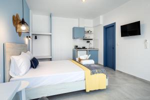 a bedroom with a large bed and a kitchen at Ifigeneia Premium Villa in Limenaria