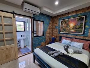 a bedroom with a bed with a painting on the wall at Turtle Nest in Hua Hin