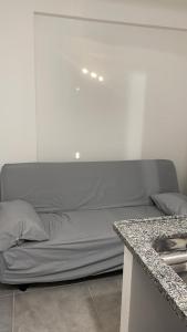 a bed in a white room with a counter at Flat 2 ao lado da UFSJ e Igreja São Francisco in São João del Rei