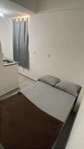 a bed in a room with a window at Flat 2 ao lado da UFSJ e Igreja São Francisco in São João del Rei