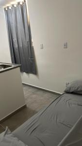 a bedroom with a bed and a black curtain at Flat 2 ao lado da UFSJ e Igreja São Francisco in São João del Rei