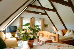 a living room with a couch and a table with flowers at Wirtshaus Jagawirt in Sommereben