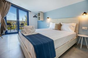 a bedroom with a large bed and a balcony at Ifigeneia Premium Villa in Limenaria