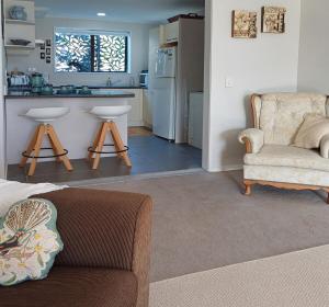 a living room with a couch and a kitchen at Driftwood Sands 3 Brm in Tairua