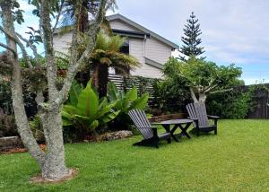 two chairs and a picnic table in a yard at Driftwood Sands 3 Brm in Tairua