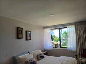 a bedroom with a bed and a window at Driftwood Sands 3 Brm in Tairua