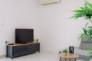 a living room with a flat screen tv on a dresser at Large and charming apartment near beach with big & sunny terrace in Sumartin