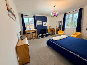 - une chambre avec un lit bleu et un bureau dans l'établissement Stylish & Modern Central Studio Apartment Free parking, à Southampton
