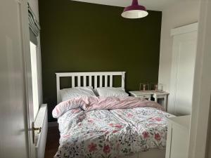 a bedroom with a bed and a green wall at 3 bed house with stunning views on Achill Island in Sraheens
