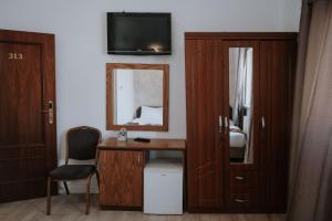 een kamer met een bureau met een spiegel en een televisie bij Victoria Hotel in Jeruzalem +32 foto's