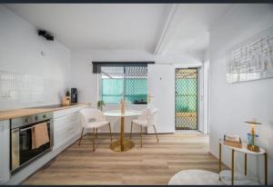 Boutique home in the heart of Surfers Paradise في غولد كوست: مطبخ مع طاولة وكراسي في الغرفة