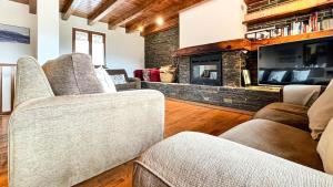 a living room with couches and a fireplace at Cal Fontcitrana, casa de montaña in Llivia