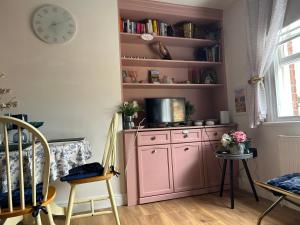 a room with a pink cabinet with a tv on it at The Cwtch in Ludlow