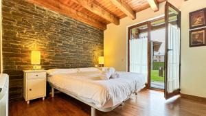 a bedroom with a bed and a brick wall at Cal Fontcitrana, casa de montaña in Llivia +27 photos