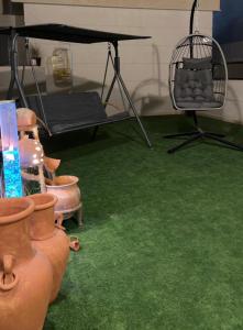 a room with green carpet and a table with a chair at Sh vellage in Sharjah