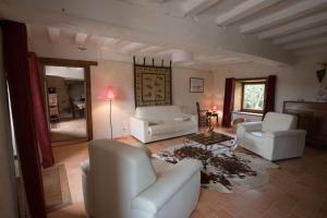 Una sala de estar con sofás blancos y una mesa. en La Grande Métairie Notz Marafin, en Paulnay