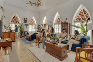 a group of people sitting in a living room at EKOSTAY - Blue Tiffany Villa in Nerul