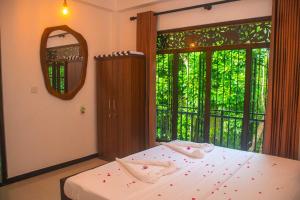 a bedroom with a bed and a large window at Orange Jesmine Unawatuna in Unawatuna
