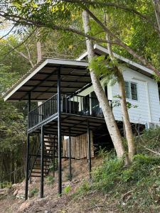 a house with a screened in porch next to a tree at Sand and Sea Koh Kood in Ko Kood