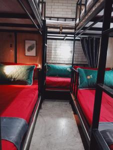 COZY Bangkok BM B&B في Amphoe Phra Khanong: سريرين بطابقين في غرفة باللونين الأحمر والأخضر