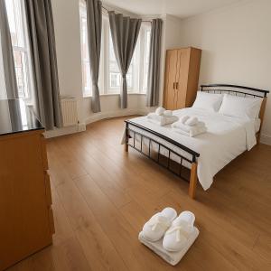 ein Schlafzimmer mit einem Bett mit weißen Handtüchern darauf in der Unterkunft Big Double room wimbledon Park in London
