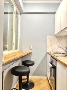 a kitchen with two stools at a counter and a sink at Studio Tokoi in Helsinki