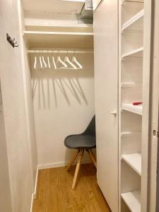 a closet with a black chair in a room at Studio Tokoi in Helsinki