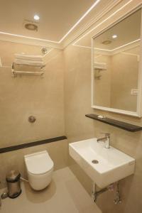 um banheiro com uma pia, um vaso sanitário e um espelho em Shri Ram Paying Guest House em Varanasi