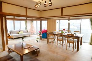 ein Wohnzimmer mit einem Tisch und ein Esszimmer in der Unterkunft 宇都宮ゲストハウス花ニ嵐 in Utsunomiya