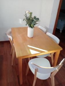 een houten tafel met een vaas met een plant erop bij ÁTICO RESIDENCIAL MARIANA parking privado y piscina in Rincón de la Victoria +20 foto's
