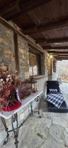 um banco num quarto com uma parede de pedra em Cozy Stone Retreat em Palaios Agios Athanasios