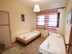 duas camas em um pequeno quarto com janela em Casa Plagia by RentalsPro - Nea Plagia Halkidiki em Nea Plagia