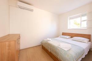 een slaapkamer met een bed, een dressoir en een raam bij Apartments Breza in Razvala