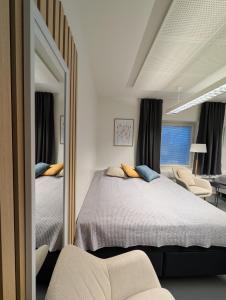 een slaapkamer met twee bedden en een spiegel bij Kotimaailma - Vihtyisä Hostelli in Kokkola +25 foto's