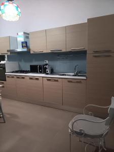 a kitchen with a sink and a chair in it at Villetta Angela in Torre San Giovanni Ugento +21 photos
