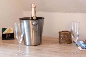 a bottle of champagne in a bucket on a table with wine glasses at Ferienwohnung Krabbe in Manslagt +13 photos