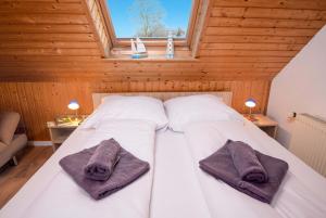 a bedroom with a bed with two towels on it at Ferienwohnung Hummer in Manslagt