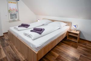a bed with white sheets and purple towels on it at Ferienwohnung Auster in Manslagt
