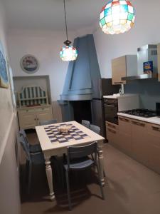 a kitchen with a table with chairs and a stove at Villetta Angela in Torre San Giovanni Ugento