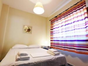 um quarto com uma cama e uma janela com toalhas em Casa Plagia by RentalsPro - Nea Plagia Halkidiki em Nea Plagia