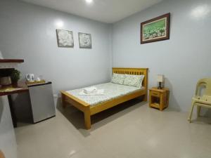 ein Schlafzimmer mit einem Bett und einem Tisch darin in der Unterkunft Grae’s Apartelle in Moalboal