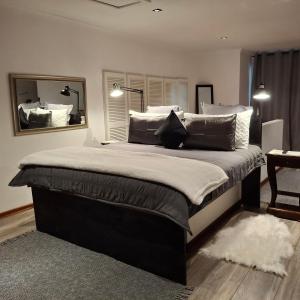 a bedroom with a large bed with pillows and a mirror at Mpushini Falls Resort in Eshowe