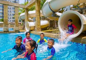 a group of children in the water at a water park at Nature Home - Swiss Garden Resort Residences - Weekend Free Breakfast in Kuantan