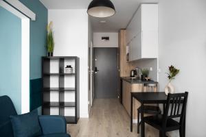 a kitchen and living room with a table and chairs at ADLER Apartments in Łódź