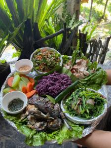 een bord met eten met vlees en groenten op een tafel bij MT House With Mountain View - Sa Pa Trekking Tour in Sa Pa